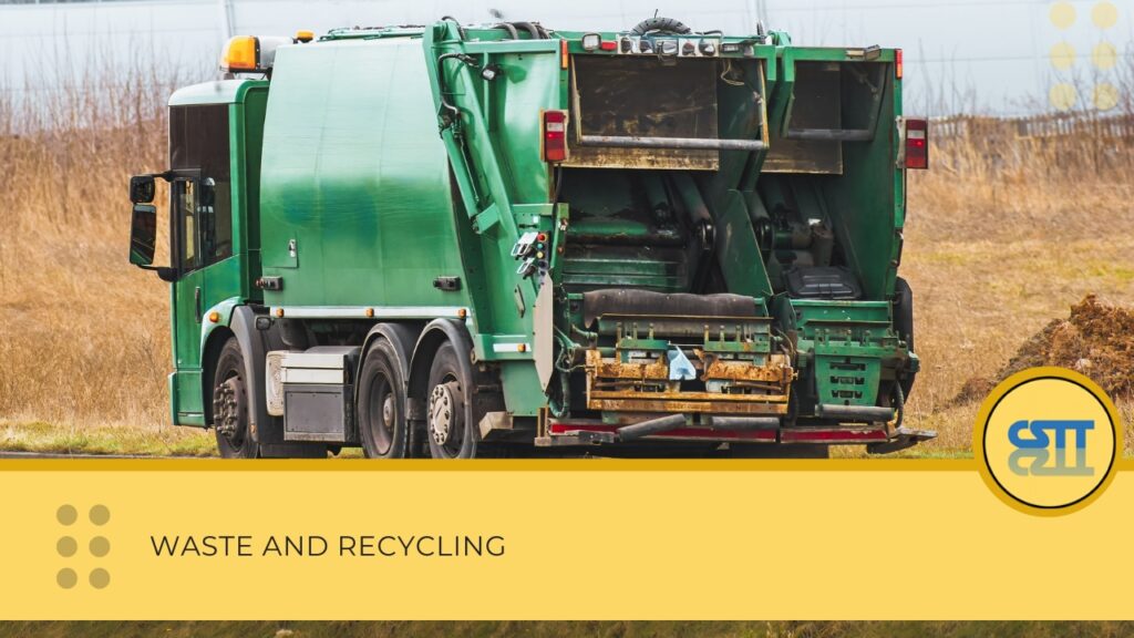 A green garbage truck driving along a rural road