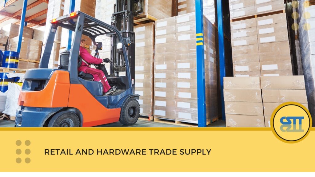 A worker operating an orange and blue forklift in a warehouse filled with stacked cardboard boxes
